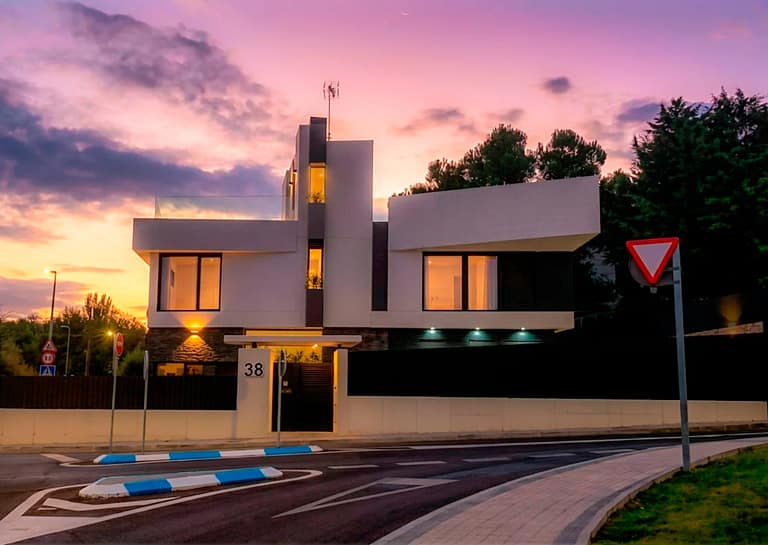 Casa KA en Las Rozas de Madrid: fachada al atardecer con iluminación exterior